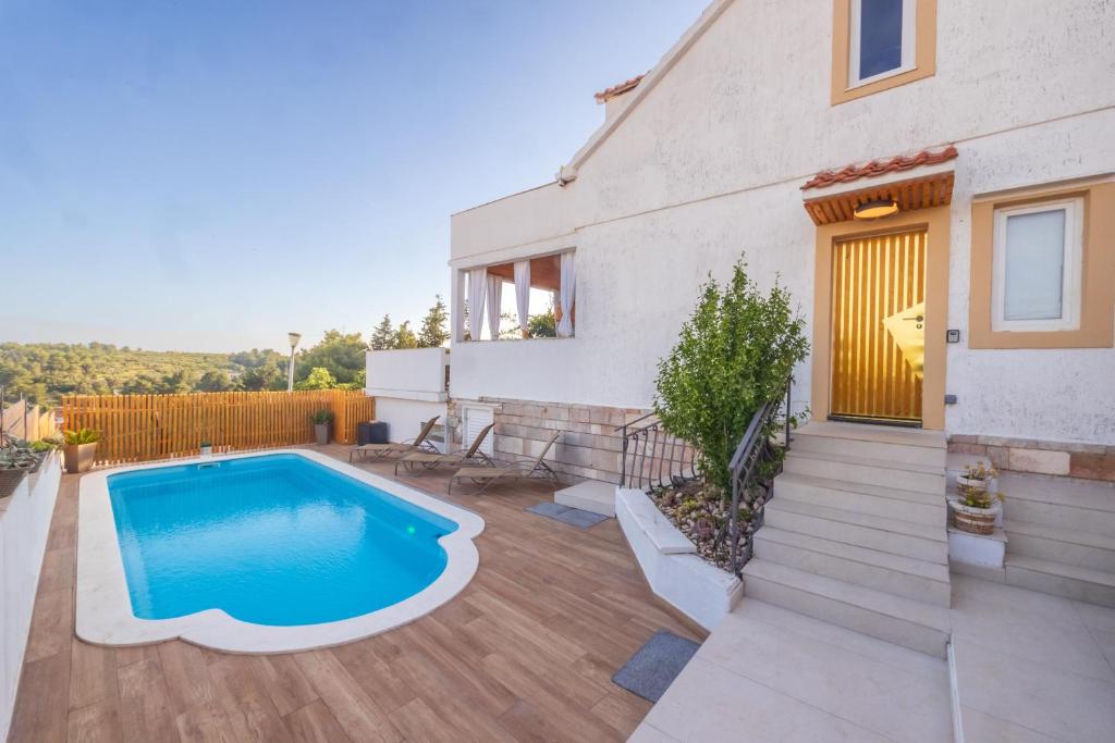 米欧纳Villa Oasis with private pool的一个带游泳池和房子的后院