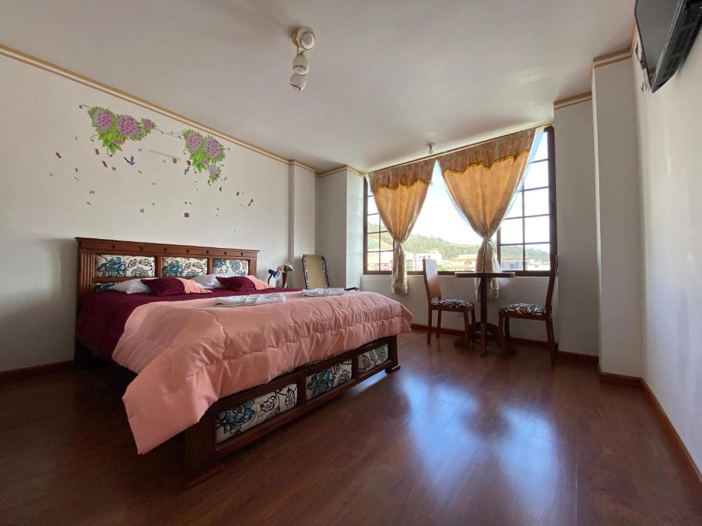 奥塔瓦洛Hostal Arauco的卧室配有床、桌子和窗户。