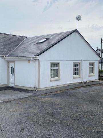 巴利瓦根JMD Lodge - Self Catering Property in the heart of The Burren between Ballyvaughan, Lisdoonvarna, Doolin and Kilfenora in County Clare Ireland的白色房子,有屋顶