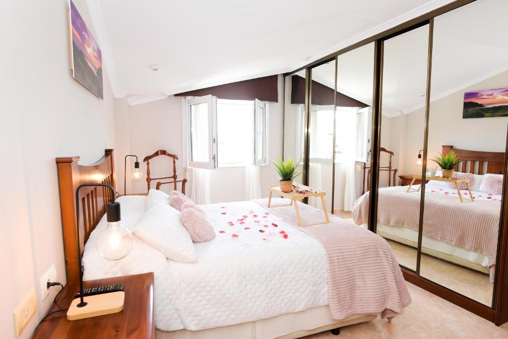 菲尼斯特雷VelayLi - Apartamento en el centro de Finisterre的一间卧室设有两张床和大镜子