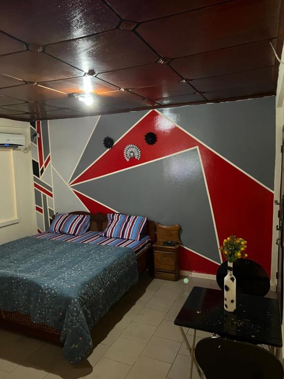 科纳克里Studio meublé à Conakry的一间卧室设有一张床和红色及白色的墙壁