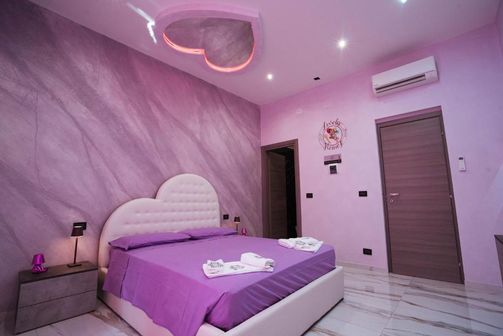 热那亚Lovely homes的粉红色的卧室,配有一张带心形床头板的床