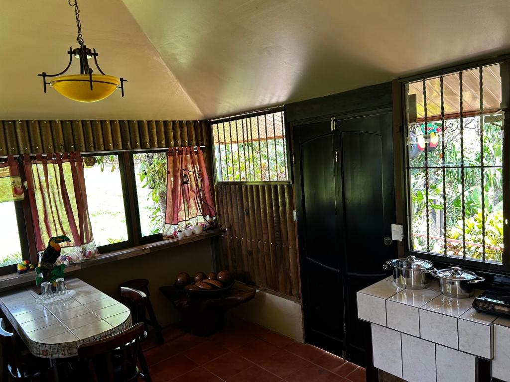 TamborCabaña en Alajuela en lugar tranquilo y con mucha naturaleza.的厨房配有桌子和一些窗户。