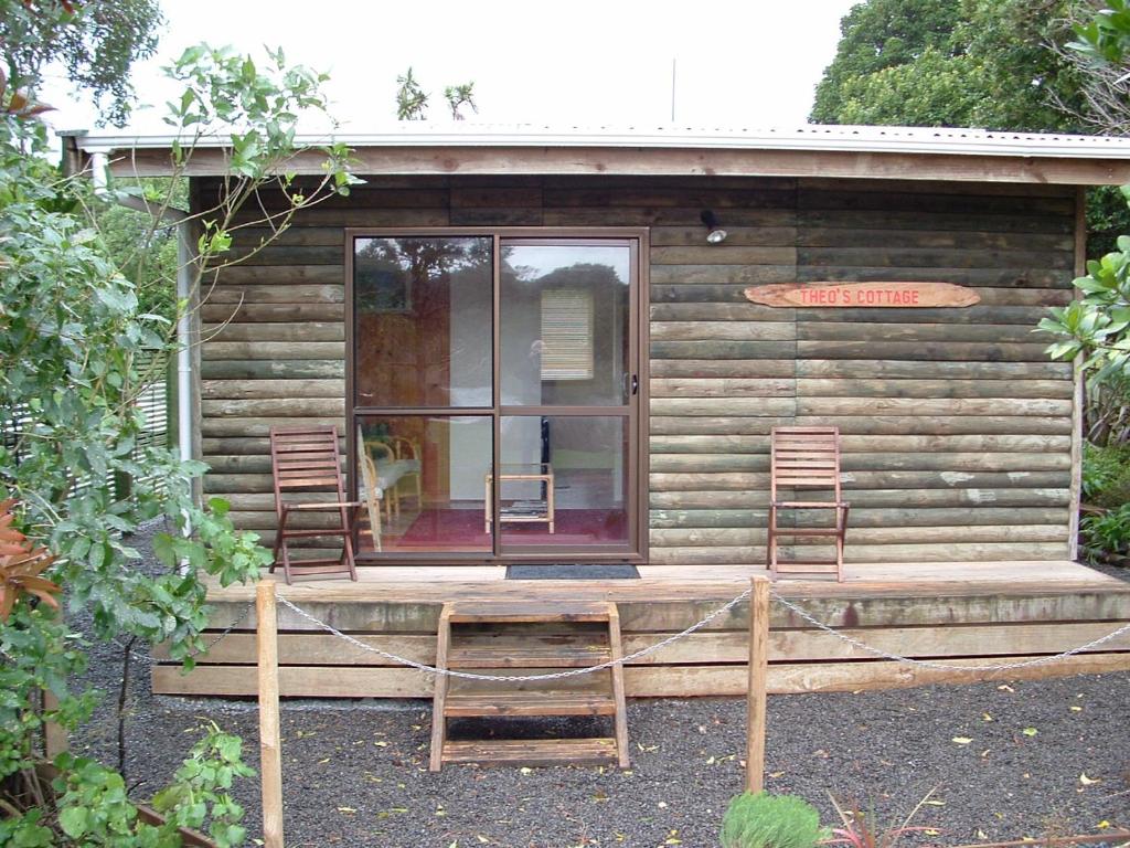 怀卡奈Theo's Cottage的小木屋前的两把椅子和一张桌子