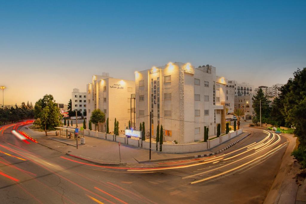 安曼Al Basem Hotel的街道上建筑物和交通的城市