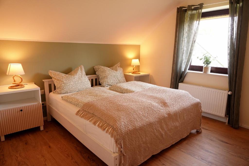 霍尔斯泰因地区诺伊斯塔特FeWo Suite Spaltsberg am Binnenwasser的一间卧室配有带2个床头柜和1扇窗户的床