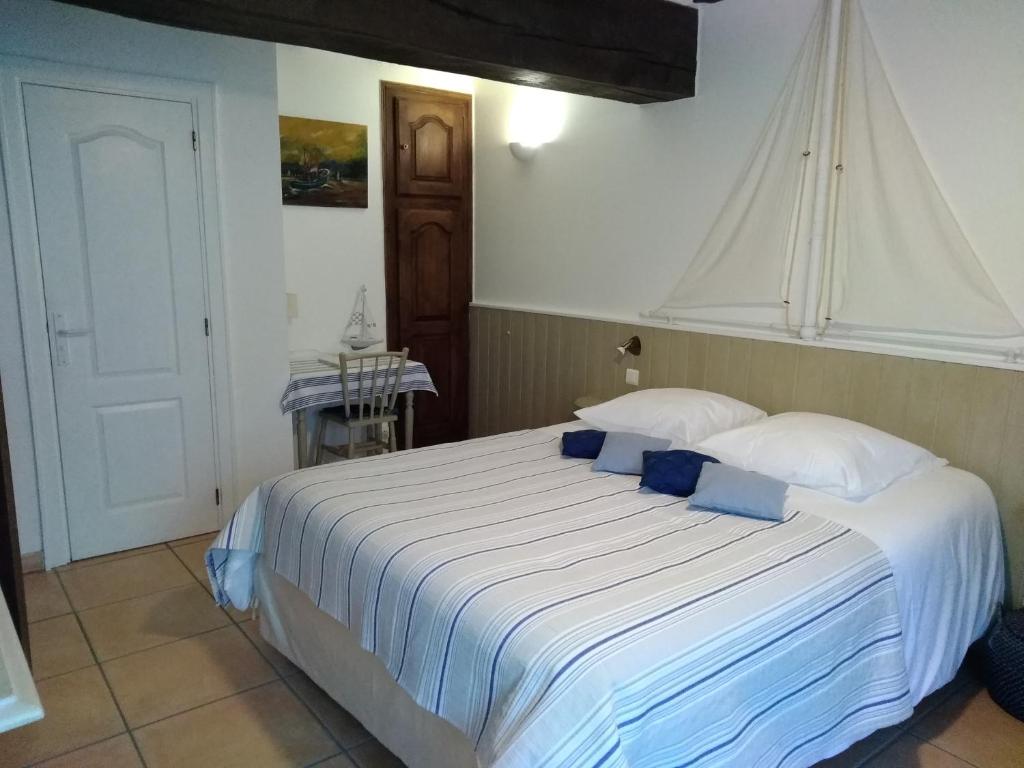 萨尔Maison d'hôtes de charme ttakoinenborda的卧室配有带蓝色枕头的大型白色床