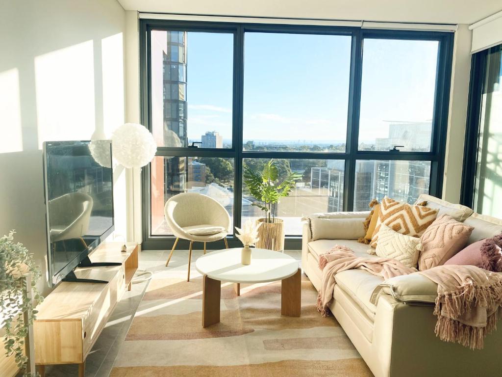 悉尼Central Apartment St Leonards的客厅配有沙发和桌子