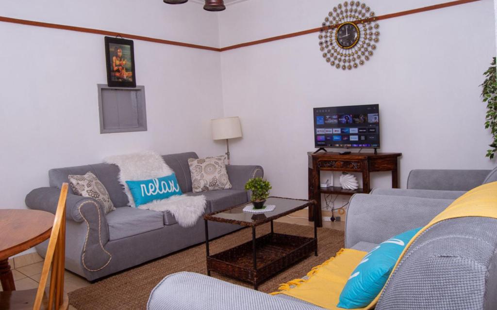 内罗毕Elegant Touch Home - 2 Bedroom House in Karen的客厅配有两张沙发和一台电视机