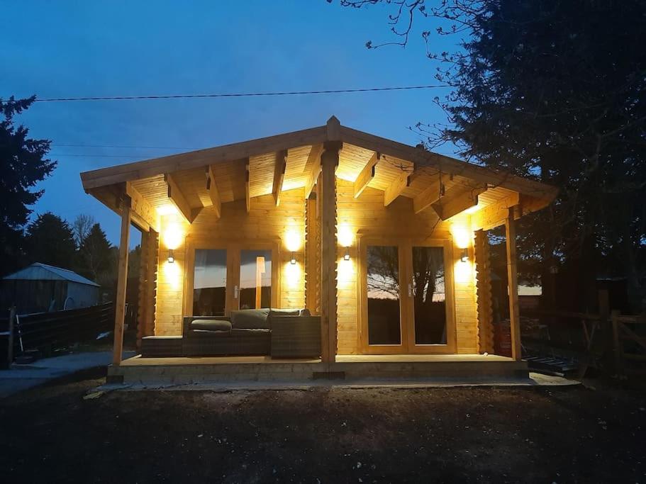 斯沃弗姆Bishy Barnabees country lodge with hot tub的一座带灯的小型木屋