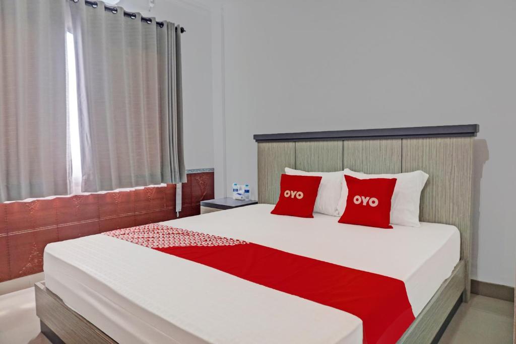 BanjarbaruOYO 92518 De Luna Hotel的一间卧室配有一张带红色枕头的大床