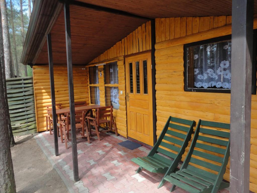 奥塞佩尔Ośrodek Wypoczynkowy Jaszczurka的小屋配有两张绿色椅子和一张桌子