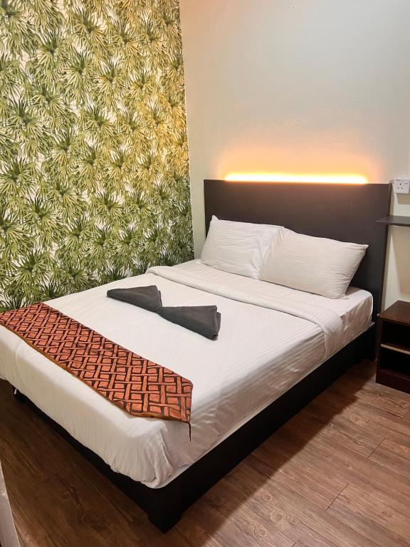 伯恩仓Hotel Citra的一间卧室配有一张带白色床单和墙壁的床。