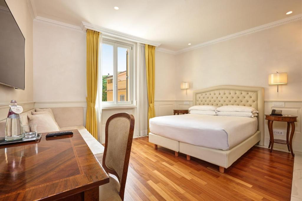 罗马德格里阿提斯缇酒店的一间卧室配有一张床、一张桌子和一张桌子