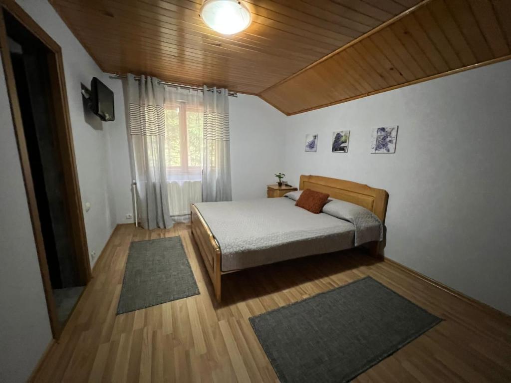 杜劳Pensiunea Lu' Movila的一间卧室配有一张床和一台电视