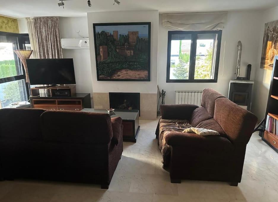 阿尔沃洛特Casa con picina en Granada.的客厅配有两张沙发和一台电视机