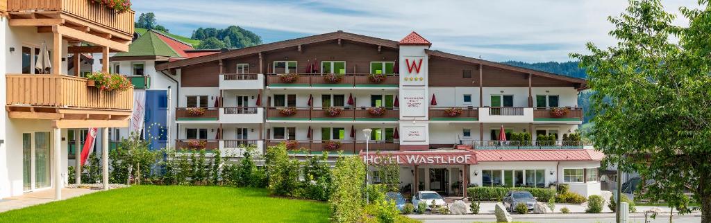 涅德劳Hotel & Alpin Lodge Der Wastlhof的一间大型酒店,前面有一个绿色草坪