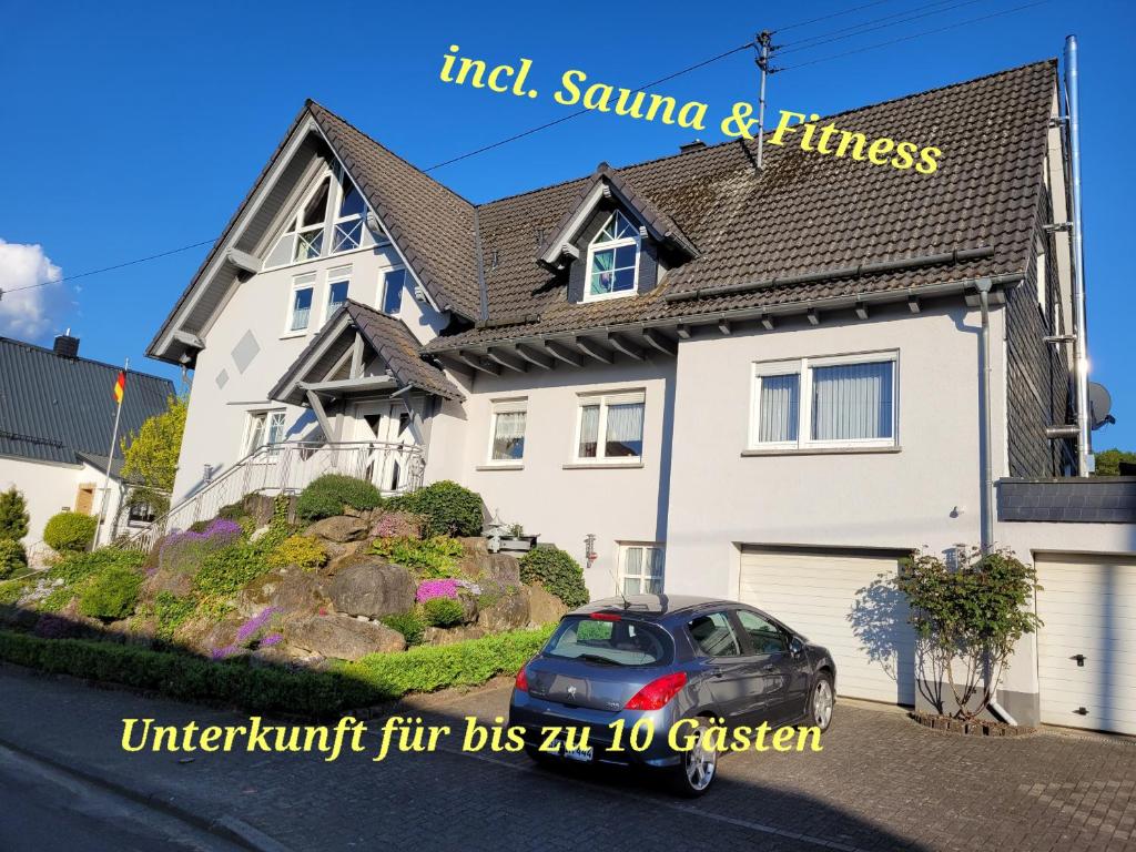 DerschenFerienwohnung Fitness Entspannung Sauna im Westerwald的前面有停车位的房子