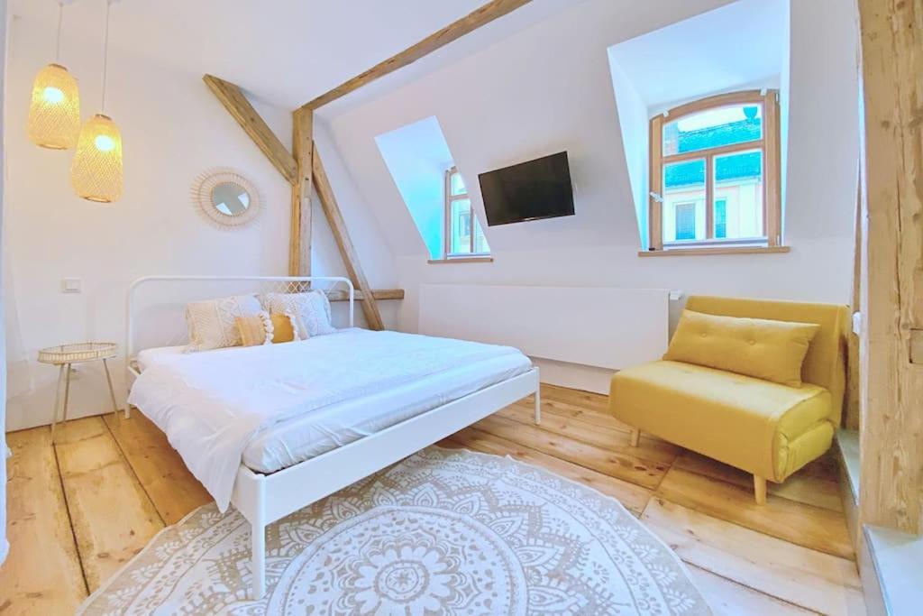 霍夫Zentrale 1-Zimmer-Ferienwohnung mit digitalem Check in的卧室配有白色的床和黄色椅子