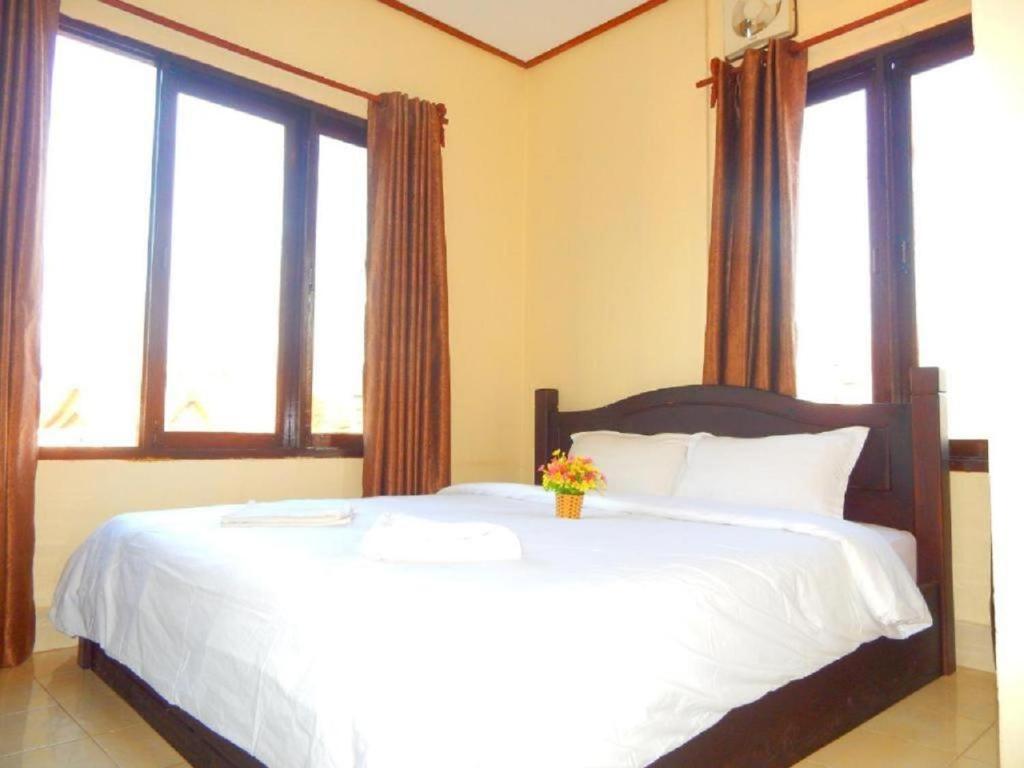 万荣DokPhut Guesthouse的卧室设有一张带窗户的白色大床