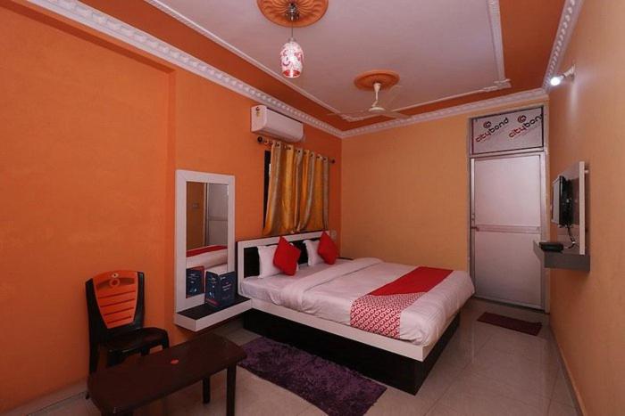 RāmgarhHOTEL J B PALACE的一间卧室配有一张床和一台电视