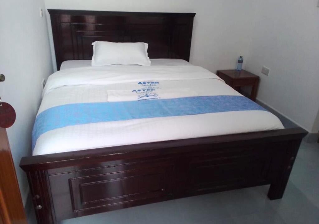 AwasiAster Suites Kisumu的床上有蓝色和白色的毯子