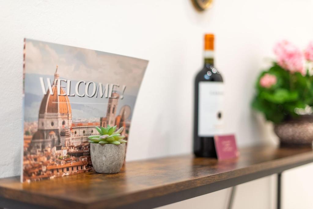 佛罗伦萨Luxury Home Il Giglio的一瓶葡萄酒和一张桌子上的植物