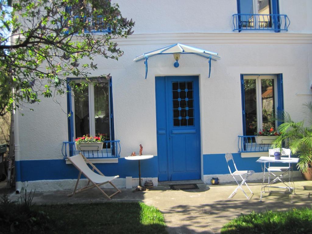 马拉科夫薛伯努瓦花园住宿加早餐旅馆的蓝白色的房子,配有椅子和遮阳伞