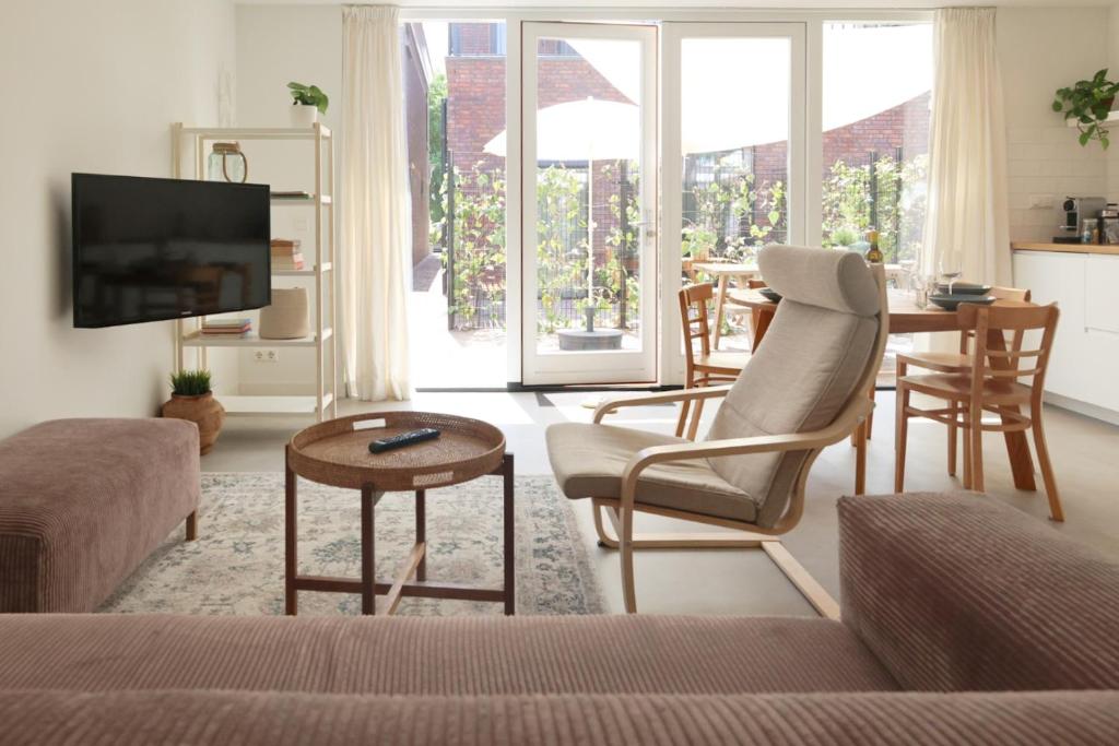 海边的艾格蒙特Zilt aan Zee的客厅配有沙发和桌子