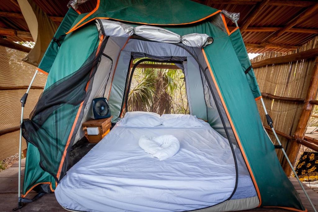 奥尔沃克斯岛Skycamp Camping Holbox的帐篷内有心形的床