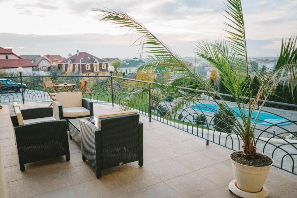 奥拉迪亚APARTHOTEL Panoramis Residence的一个带椅子和植物的阳台,以及一个游泳池