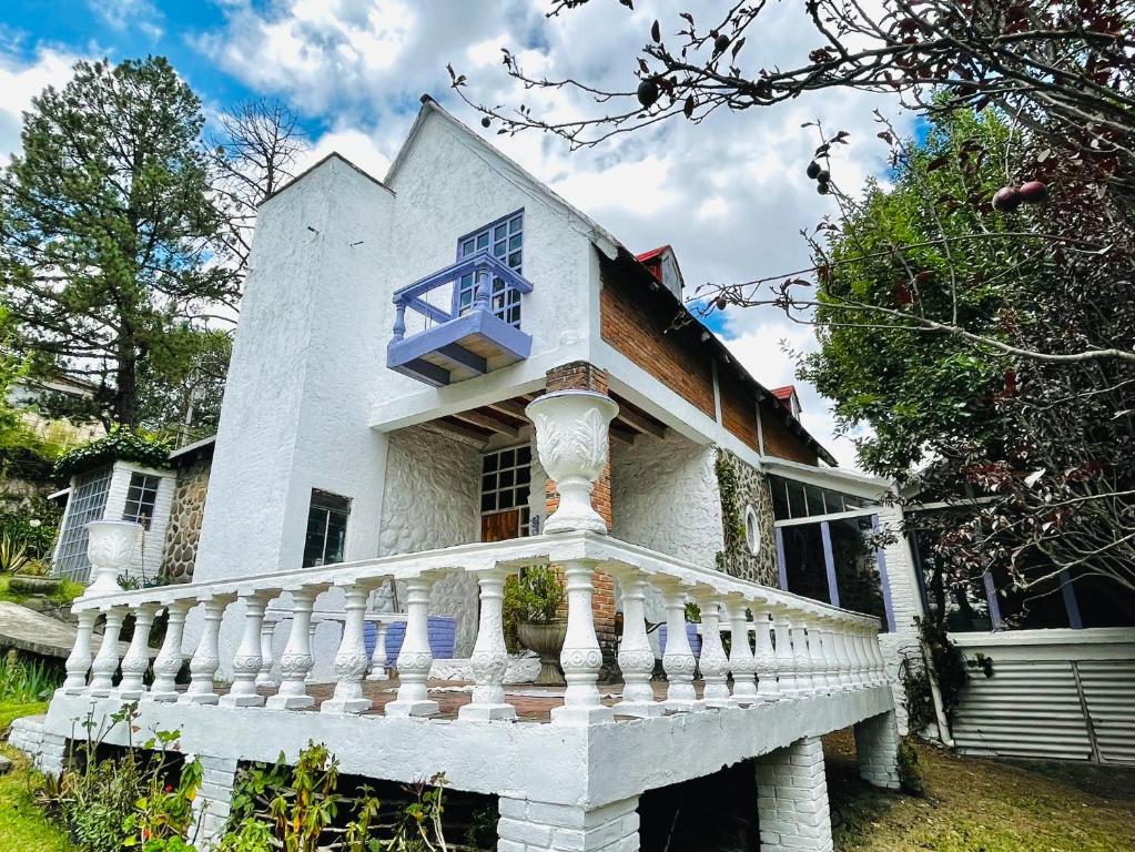 卡尔波镇Villa Ledezma的带阳台和楼梯的白色房屋