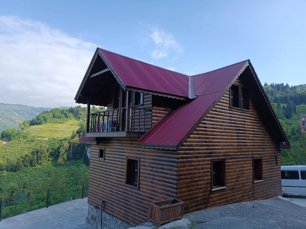 MackaDiamond Tree House的小木屋设有红色屋顶和阳台