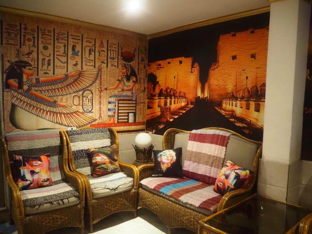 卢克索Venus hotel luxor 日本人 大歓迎的一间设有两把椅子和一幅画墙的房间