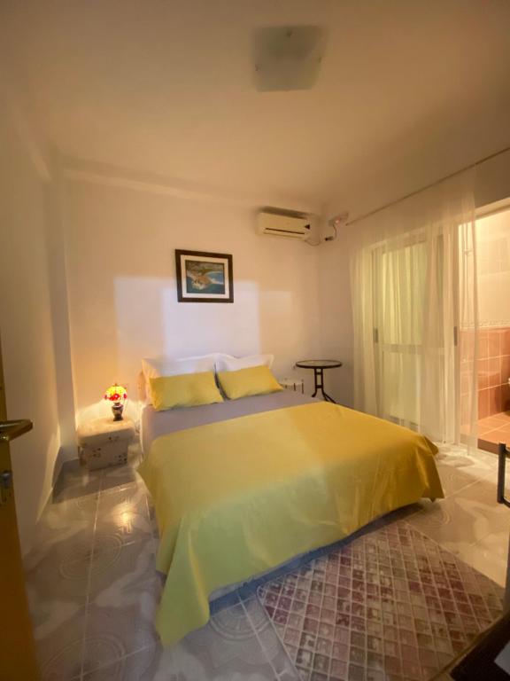 乌尔齐尼Guest House Nuhii的一间卧室,卧室内设有一张黄色的大床