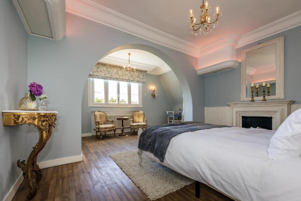 Saint-MathieuVilla Verte的一间卧室配有一张大床和一个吊灯。