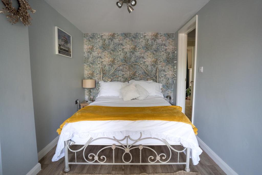 布莱顿霍夫Driftwood by the Sea的一间卧室配有一张带花卉壁纸的床