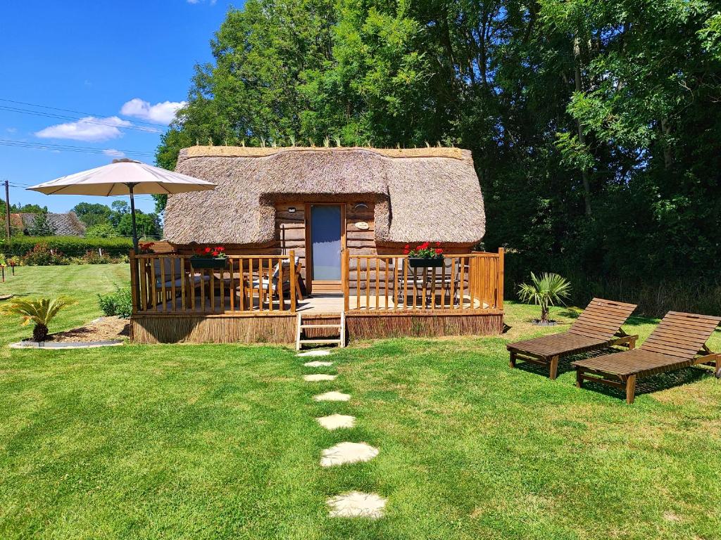 Saint-Martin-Saint-FirminLes Mini-Chaumières的小木屋设有茅草屋顶和庭院