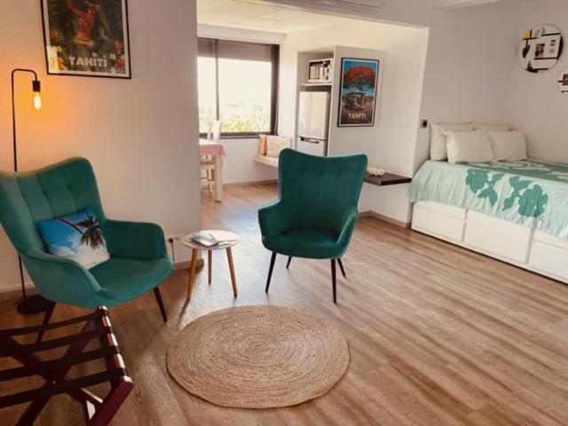 帕皮提Studio Teiki - calme, proche centre-ville, ferry & aéroport的客厅配有两把椅子和一张床