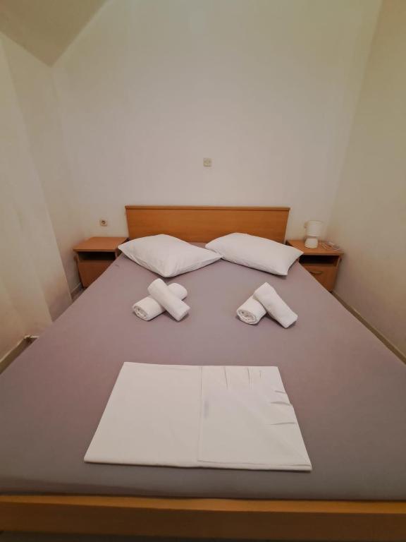 DrašniceApartmani ante 3的一张带两个枕头的床和两条毛巾