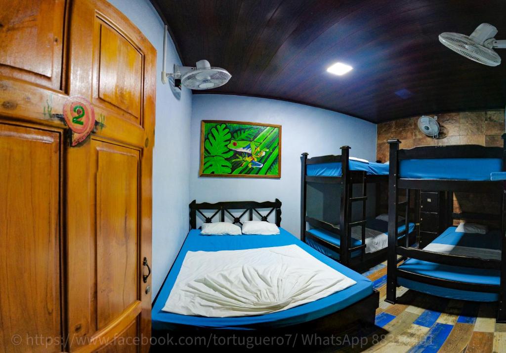 托尔图格罗Hostel Tortuguero 7BackPackers的配有一张床和两张双层床的房间