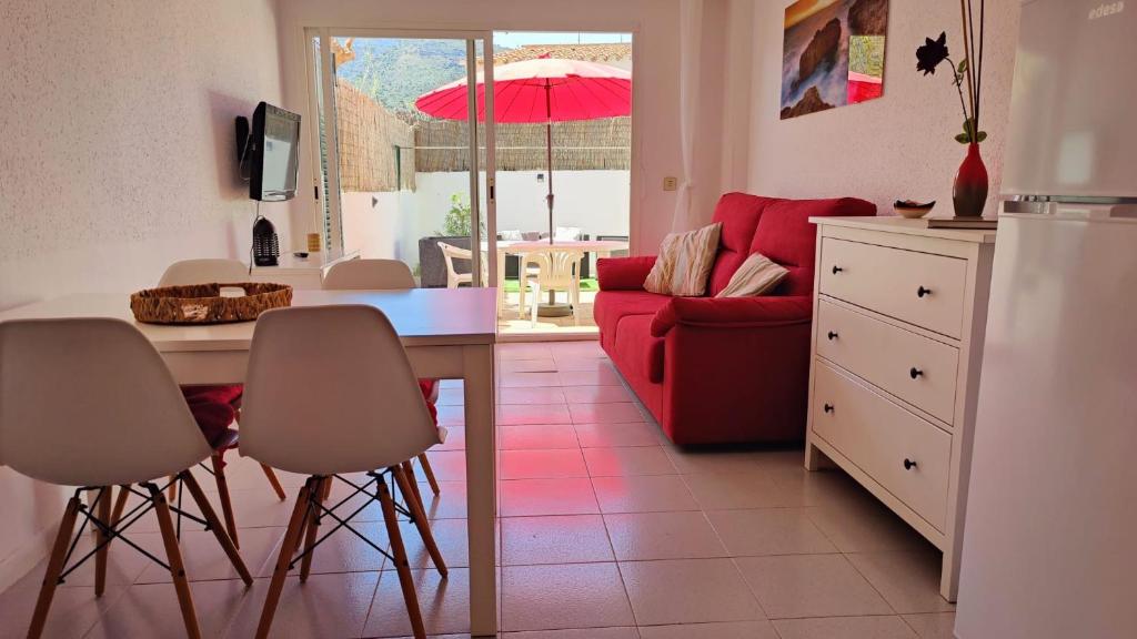 德拉塞尔瓦港Port de la Selva apartament的厨房以及带桌子和红色沙发的客厅。