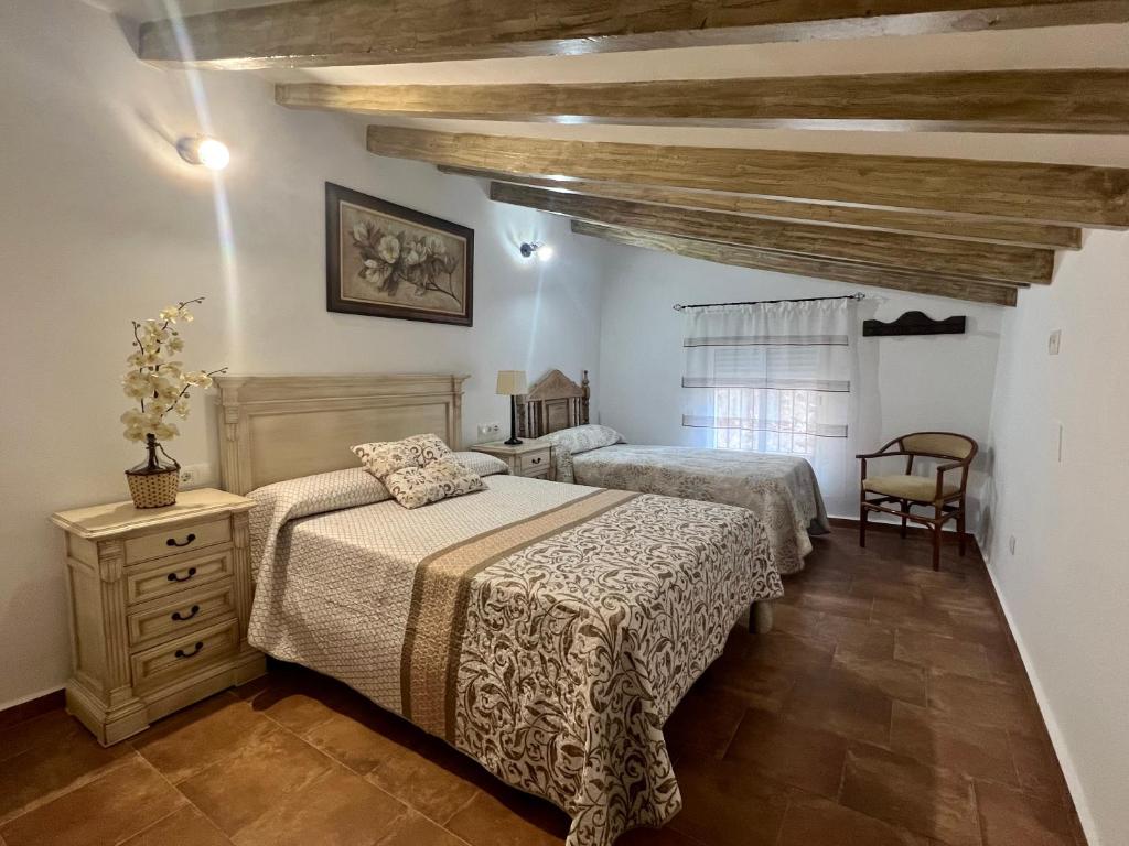 马拉加Casa rural Las Casillas的一间卧室设有两张床和木制天花板