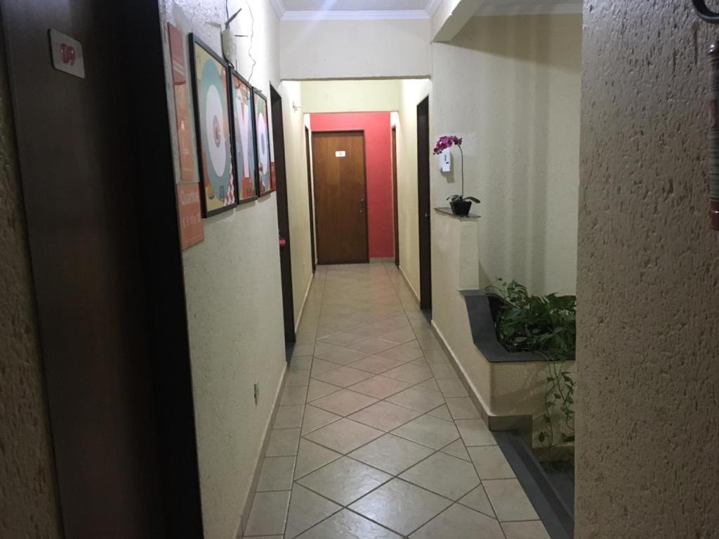 里贝朗普雷托HOTEL CENTER Ribeirão的走廊上设有红色的门,铺有瓷砖地板