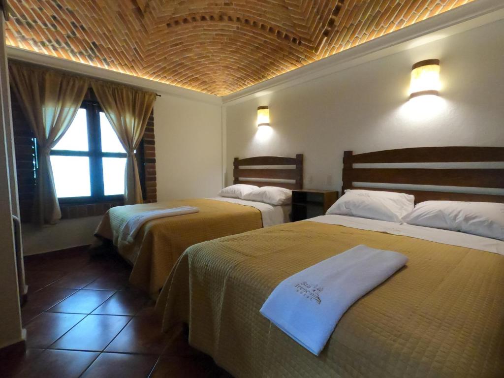 乔卢拉Hotel Santa Irene的酒店客房设有两张床和窗户。