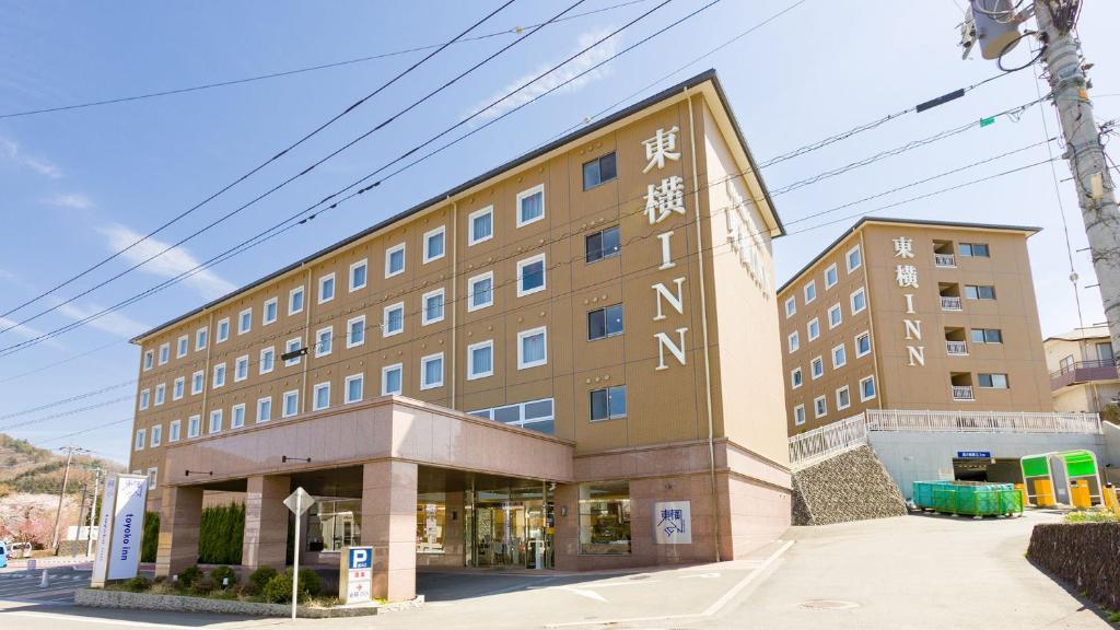 富士河口湖Toyoko Inn Fuji Kawaguchiko Ohashi的一座大建筑,旁边写着书