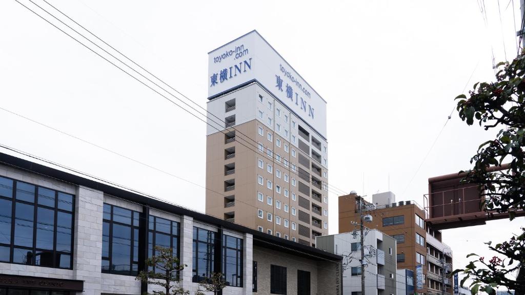 静冈Toyoko Inn Shizuoka eki Minami guchi的一座高大的建筑,上面有标志