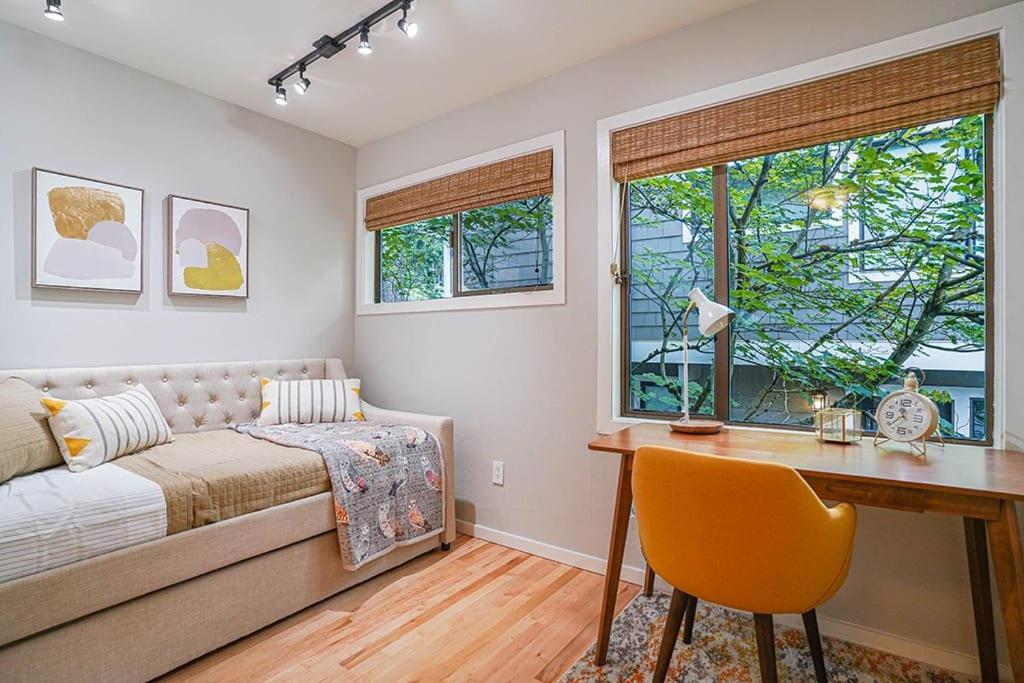 贝尔维尤Sunlit contemporary Bellevue Home w a Lush Garden的卧室配有1张床、1张书桌、1张桌子和窗户。