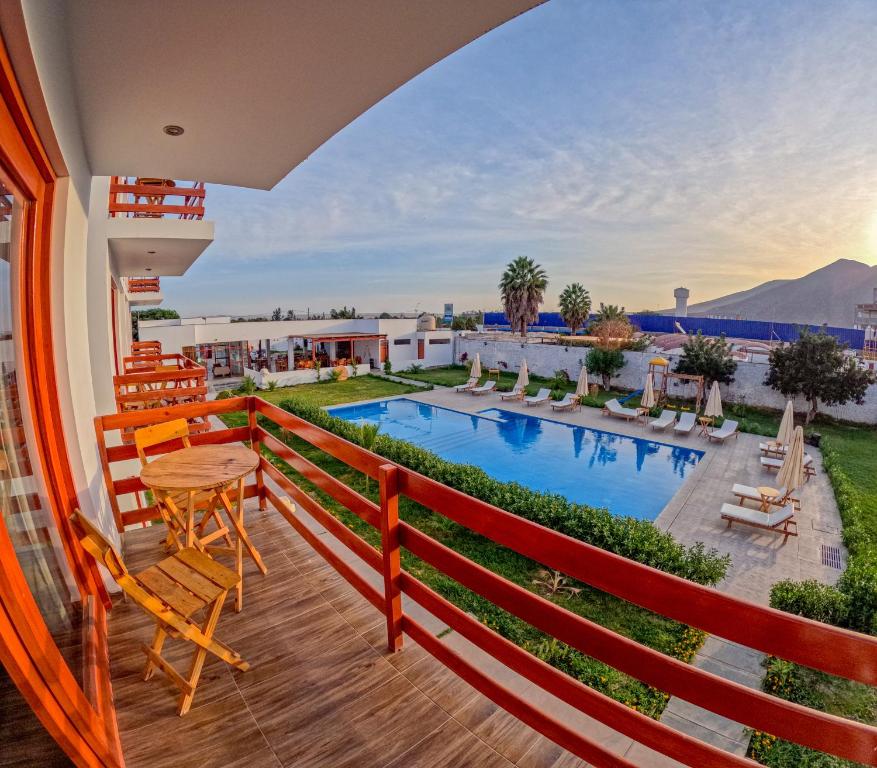 伊察Hotel La Colina的一个带桌椅的阳台和一个游泳池
