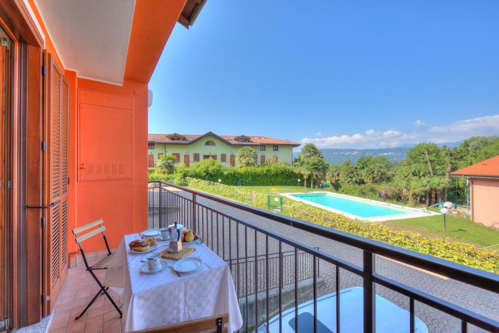 拉韦诺Cottage Del Lago - Happy Rentals的阳台配有桌子,享有游泳池的景色